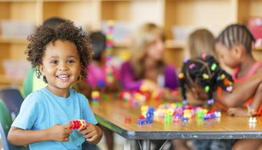 Diverse class of preschool students playing with blocks