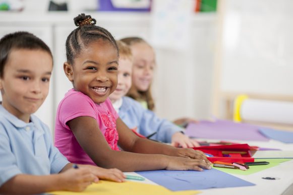 Coloring Together in Class A multi-ethnic group of elementary age children are coloring on construction paper and making an art project in class.